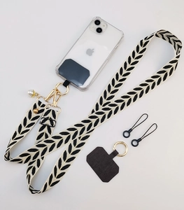 Detail of adjustable floral fabric phone strap with gold hardware and pearl charm