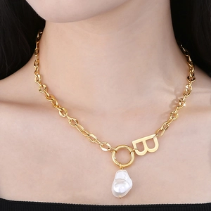 Detail of gold B-letter pendant with baroque pearl on thick chain necklace