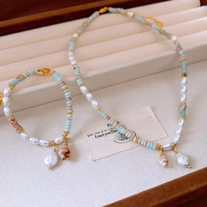 Detail of turquoise beads and freshwater pearls necklace with a small seashell pendant