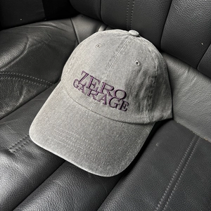 Detail of Zero Garage purple embroidery on washed gray cotton baseball cap