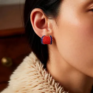Vintage C-shape square stud earrings with red and blue beads on a beige coat model