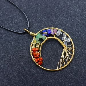 Macro shot of handmade golden Tree of Life pendant with colorful chakra natural stones