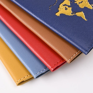 Macro shot of PU leather passport covers with gold foil world map and white stitching