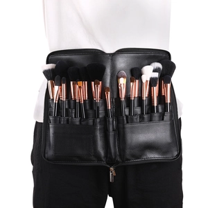 Close-up of a black PU leather makeup brush belt bag worn by a model with various brushes