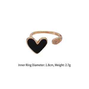 Detail view of gold open ring with black enamel heart and pave zircon inlay, 1.8cm diameter