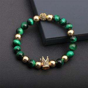 Macro shot of tiger eye beads with gold crown charm and micro-pave black zircon ball