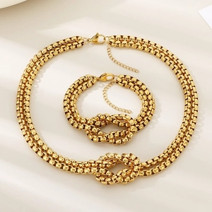 Close-up of gold layered knot necklace and bracelet set with lobster clasp and extender