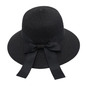Detail of woven straw texture and elegant black ribbon bow on a wide brim sun hat