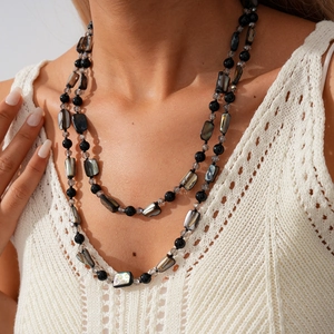Détail du collier bohème double épaisseur avec perles noires et morceaux de nacre