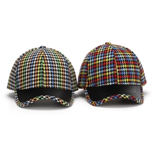 Detail of colorful houndstooth fabric pattern and premium black leather brim on baseball cap