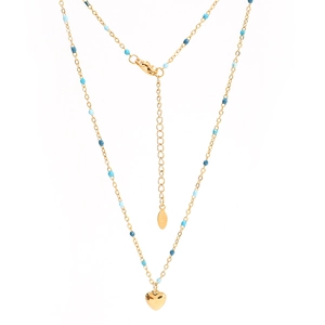 Détail du collier en chaîne dorée avec perles bleues, pendentif cœur et fermoir homard
