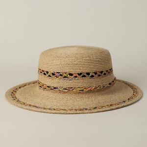 Macro detail of hand-woven colorful raffia braid on a flat top boater straw hat