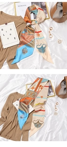 Flat lay of vintage blue and orange silk twilly scarf styled with a brown handbag