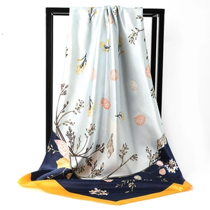 Detail of silk scarf with sea shell patterns and soft blue texture hanging on a frame
