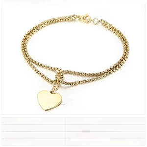 Detail of gold double-layer pearl chain bracelet with engraved MOM heart pendant