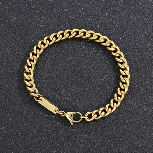 Detailed view of golden curb chain bracelet with blank rectangular tag and lobster clasp