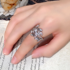 Anillo de enredadera entrelazada con hojas de circón de corte marquesa puesto en mano
