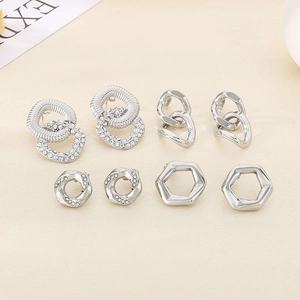Macro shot of silver geometric earrings set with sparkling rhinestones and textured metal details