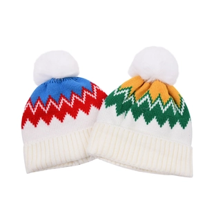 Close-up of knit hats with pom-poms, wave pattern jacquard and ribbed cuffs for warmth