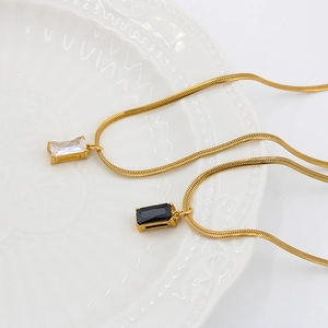 Elegant gold snake chain necklace featuring square zircon pendants on ceramic plate