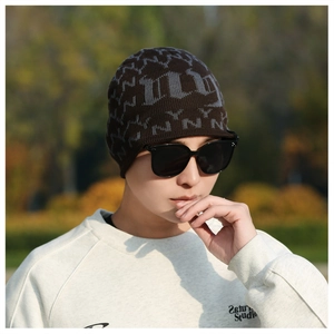 Detail of warm brown knit beanie with grey gothic letters for winter outdoor activities