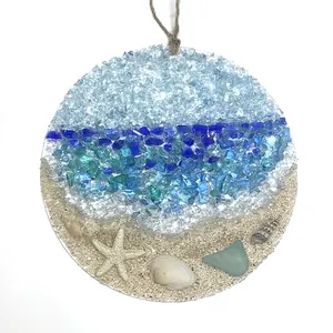 Macro shot of sea glass suncatcher with real sand, starfish, and colorful beach glass