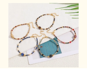 Detail of colorful beaded bracelets with natural stones and gold lobster clasp closure
