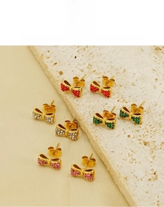 Détail de boucles d'oreilles nœud plaquées or 18 carats avec strass colorés sur pierre
