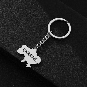 Detailed view of silver stainless steel Ukraine map pendant keychain on dark background