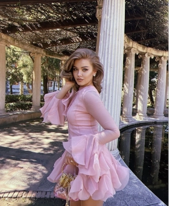 Detail of pink tiered ruffle dress with layered flared sleeves in soft chiffon fabric
