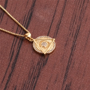 Gold Turkish eye pendant necklace with sparkling zircon crystals on brown surface