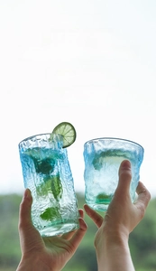 Detail of glacier texture glass cups set with lime and mint in gradient blue-green color