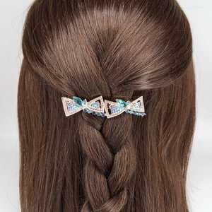 Elegant large butterfly hair clip with blue crystals on brown braided hair of a model