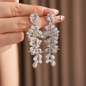 Gros plan de boucles d'oreilles pendantes en argent avec zircons et feuilles