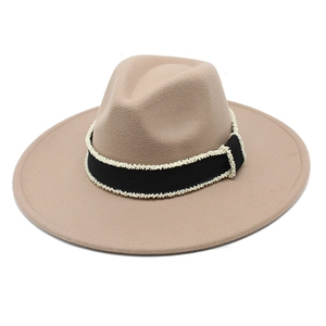 Macro detail of khaki wool fedora hat with black ribbon and white pearl bead embellishment