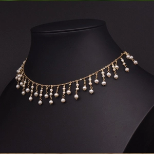 Elegant gold choker necklace with natural freshwater pearls shown on a black bust mannequin