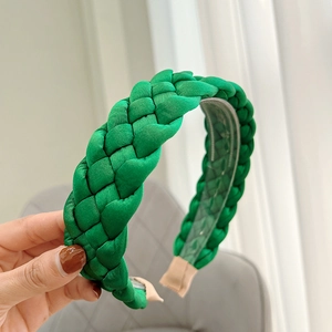 Detailed view of the woven fabric braid texture on the green headband with beige tips