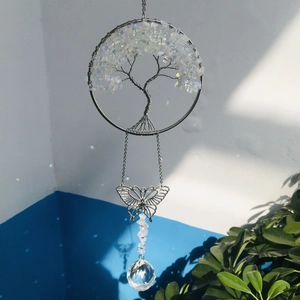 Detail of tree of life suncatcher with crystal ball prism reflecting rainbows on a wall