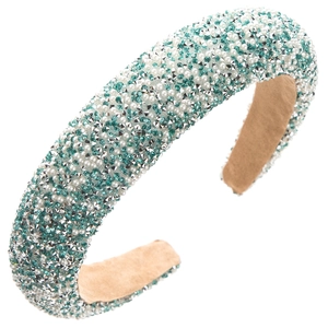 Macro shot of padded headband with light green crystals and faux pearls on soft khaki base