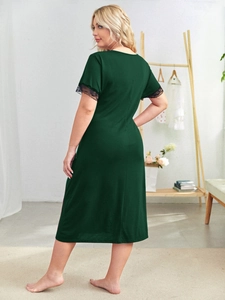 Detail of dark green dress showing black lace trim on sleeves and soft cotton texture