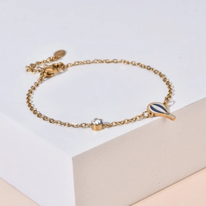 Detailed shot of gold chain bracelet featuring rhinestone and enamel hot air balloon charm