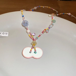 Detail view of colorful handmade beaded necklace with a pink double-circle charm pendant