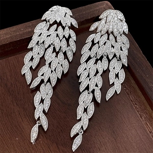 Detail view of silver tassel earrings featuring leaf shapes and sparkling zircons