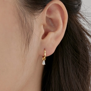 Elegant gold drop earrings with teardrop zircon pendant shown on model ear profile