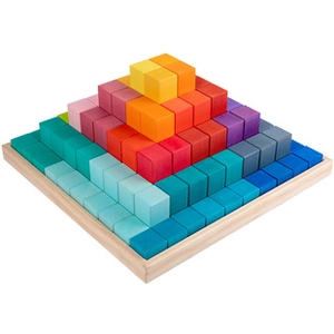 Blocs en bois arc-en-ciel empilés en pyramide sur un plateau en bois massif
