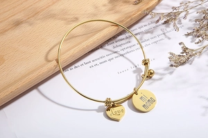 Détail du bracelet doré ajustable avec pendentifs en cœur gravés Love et mi mama