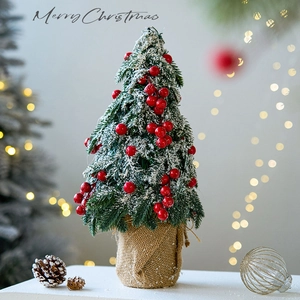 Mini cedar Christmas tree with red berries and snow on rustic burlap base