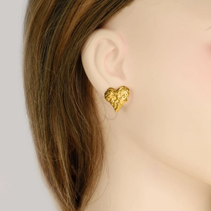 Irregular textured heart stud earrings in gold plated stainless steel on female model