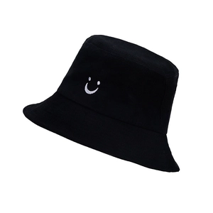Detailed view of the white smiley face embroidery on a black cotton bucket hat