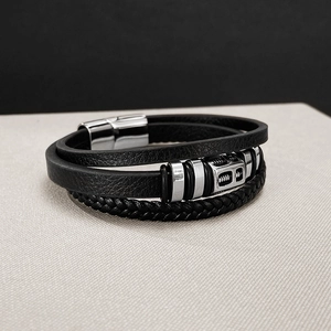 Close-up of men's multi-layer black leather bracelet with silver magnetic clasp and texture
